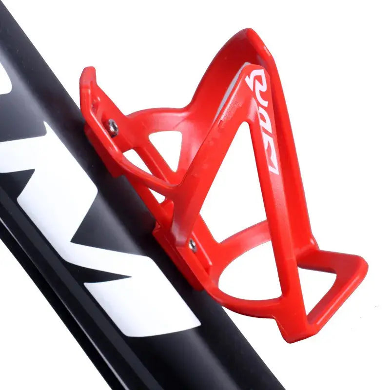 Red Maxlerz bottle cage mounted on a black bike frame