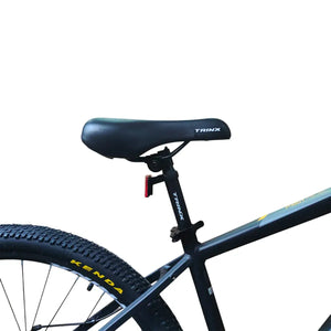 Close-up of Trinx M007 PRO mountain bike saddle, seatpost with quick-release clamp, rear reflector, and Kenda rear tire.