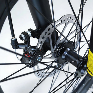 Close-up view of mechanical disc brake assembly and front wheel hub on Trinx mountain bike, isolated on white background