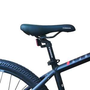 Close-up view of black Trinx bicycle saddle and adjustable seatpost, isolated on white background