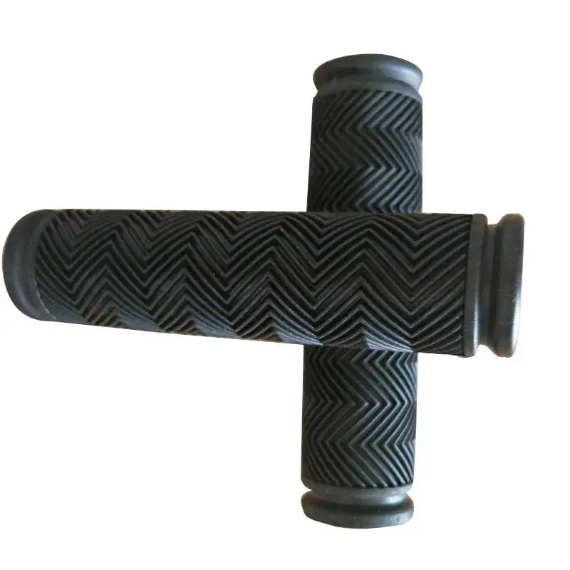 Pair of black bicycle handlebar grips with textured chevron pattern arranged in a cross shape on a white background