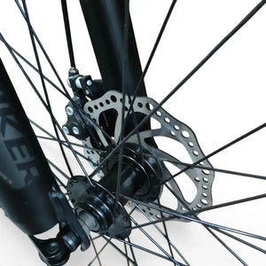 Close-up view of Trinx K024 mountain bike front mechanical disc brake rotor, caliper, wheel hub, and suspension fork