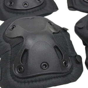 Close-up of a black protective pad showing the contoured outer shell, rivets and padded fabric edges.