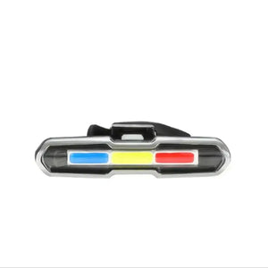 Horizontal front view of a bicycle LED tail light with three colored panels and silver trim.