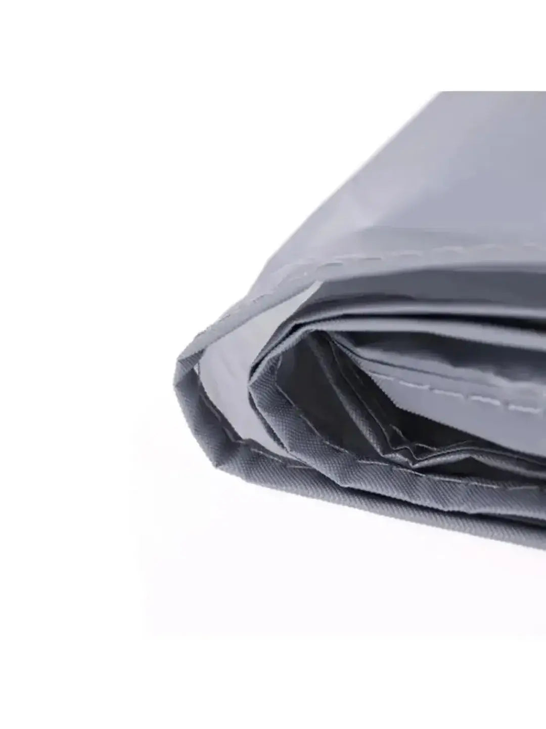 Close-up view of folded silver-gray waterproof bicycle cover showing stitched hem edges on white background