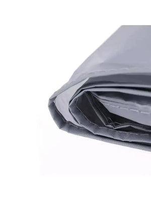 Close-up view of folded silver-gray waterproof bicycle cover showing stitched hem edges on white background