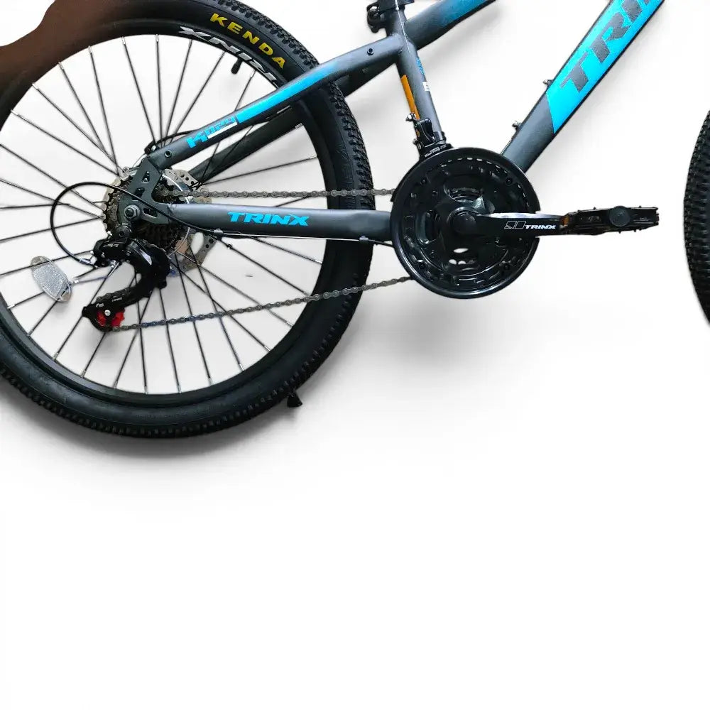 Side view of Trinx K024 mountain bike rear frame showing 24-inch Kenda tire, Shimano rear derailleur, cassette, chain, and triple crankset on a white background