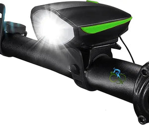 Black bicycle headlight with green trim and illuminated front LED beam, mounted on a bicycle handlebar.