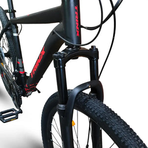 Front suspension fork and Kenda tire detail of Trinx 007 PRO 29-inch mountain bike with red TRINX logo.