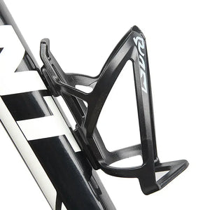 A close-up of a black Abo ElGoukh & Maxlerz bicycle water bottle cage mounted on a black and white bicycle frame against a white background
