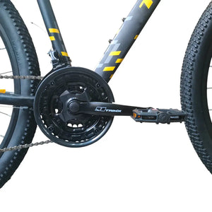 Close-up of Trinx M007 PRO mountain bike crankset, chainring, front derailleur, and pedal on a black frame with yellow accents.