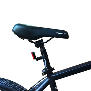 Close-up view of black Trinx bicycle saddle and seatpost, isolated on white background