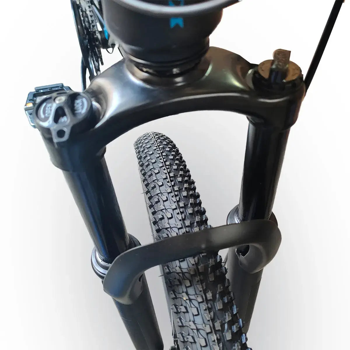Close-up view of front suspension fork arch and tire tread on Trinx K026 mountain bike, isolated on white background