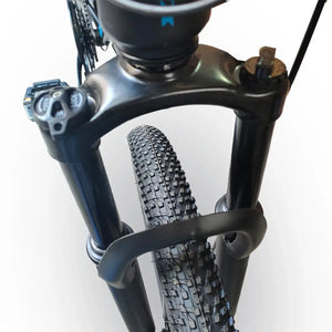 Close-up view of front suspension fork arch and tire tread on Trinx K026 mountain bike, isolated on white background